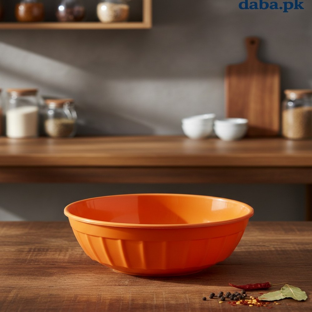 Single orange high-quality plastic serving bowl on a wooden kitchen counter with spice jars in the background.
